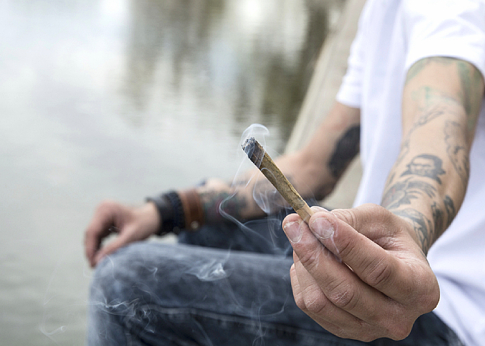 Man holding a marijuana cigarette