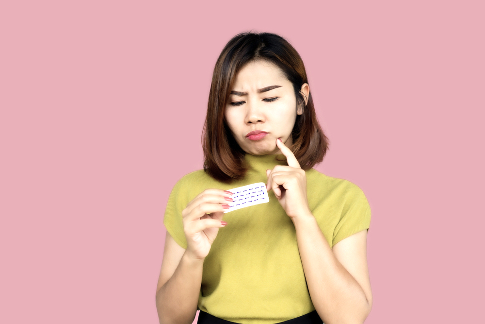 A woman in yellow blouse looking at Naltrexone with questions in her mind
