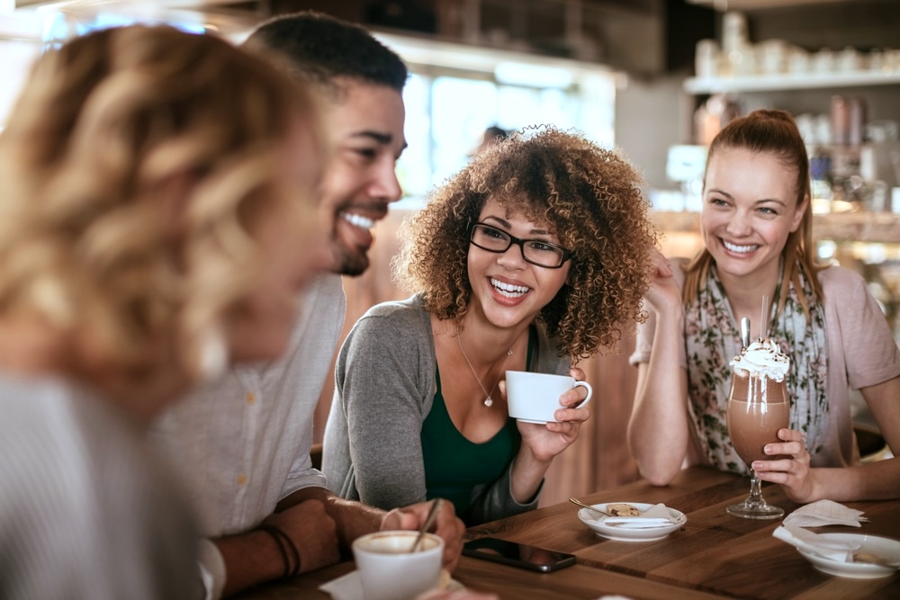 Group of friends in addiction recovery happy while drinking coffee
