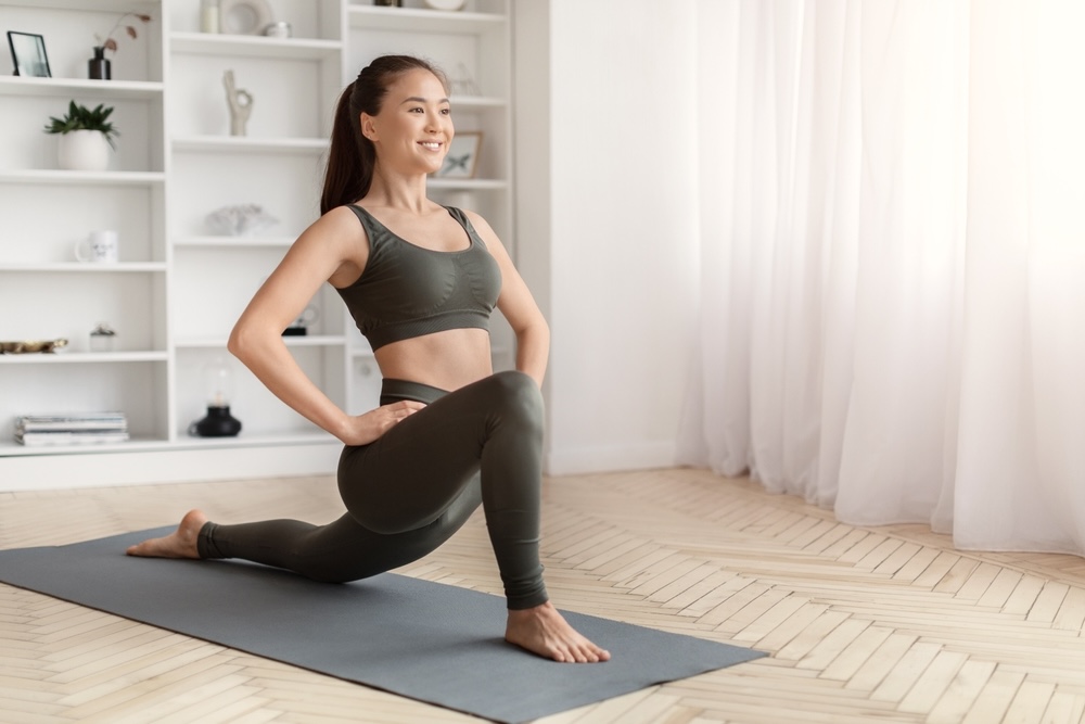 Female doing yoga indoors on a yoga mat